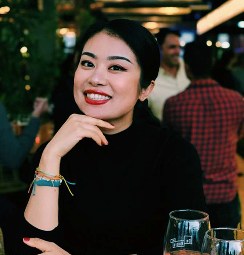 Fi, the founder of GrowthLab 360, smiling at a cafe, representing a holistic approach to wellness and personal training.
